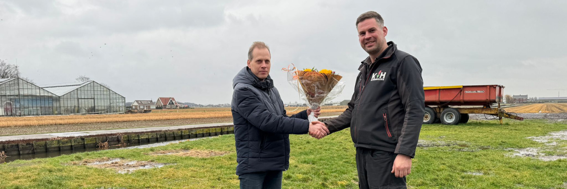 Coach overhandigt bloemen aan bloembollenkweker Ron van Haaster